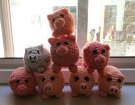 8 small knitted pigs piled in an acrobatic formation for the Thinking Rationally exhibition at the MERL