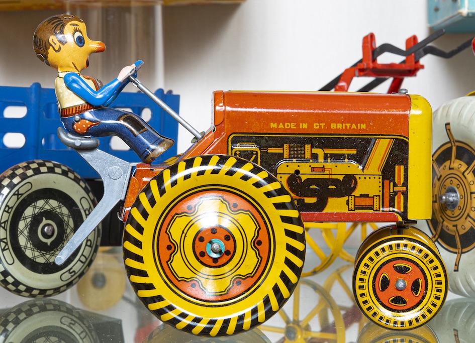 a brightly coloured tin tractor with driver