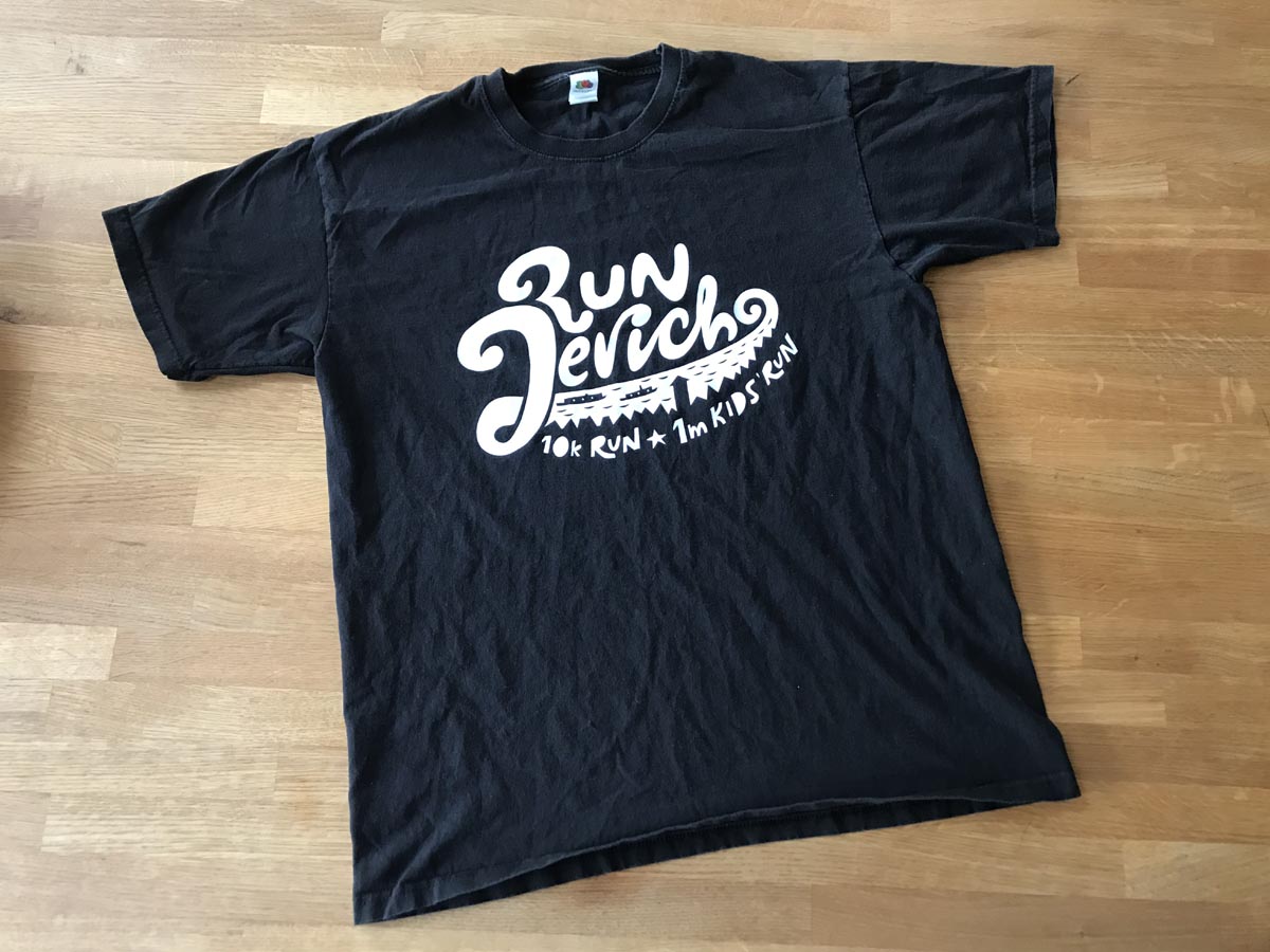 A black t-shirt with white writing reading 'Run Jericho: 10k run, 1m kids run'