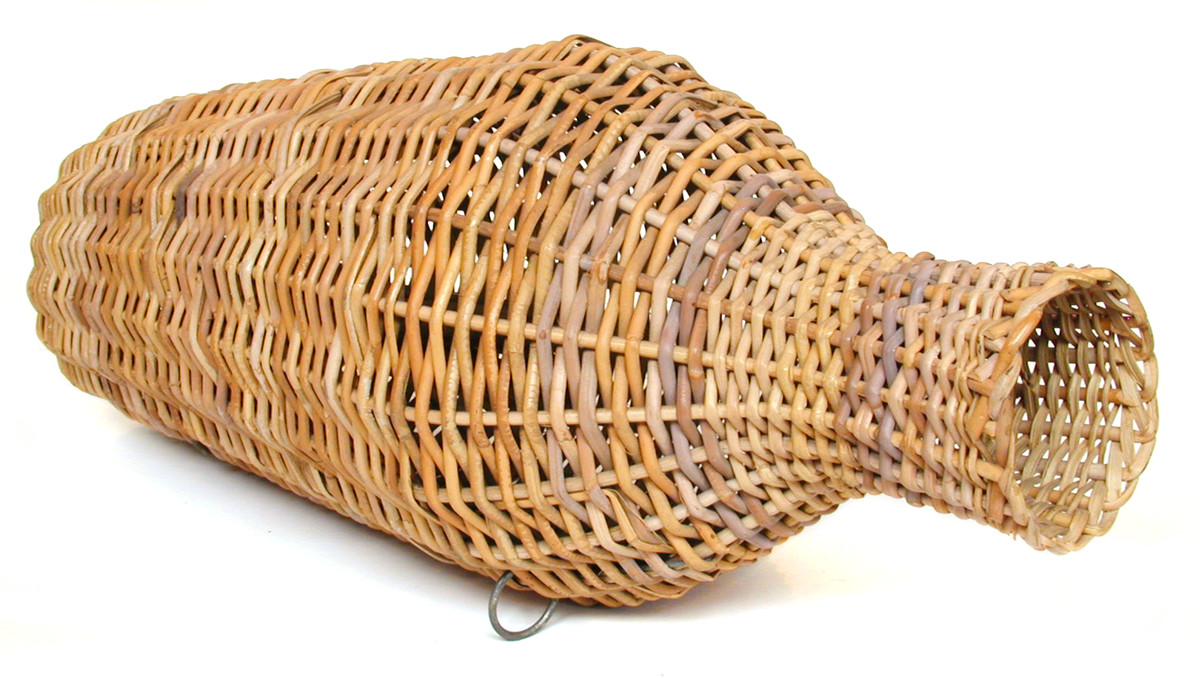  This eel trap, used for catching eels, was made by Stanley Bird of Great Yarmouth for the Museum. It is a Fenland eel trap made of cane, both round and split, with steel rings and galvanised wire. Because the pith has been removed from the cane, the trap is able to sink by itself without the need for weights. (MERL 63/606)