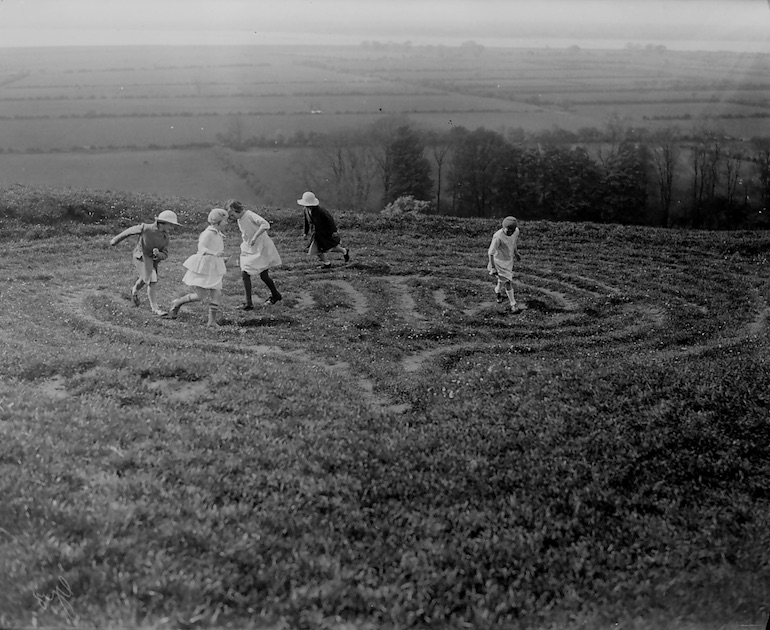 Children playing a game in a hay field
