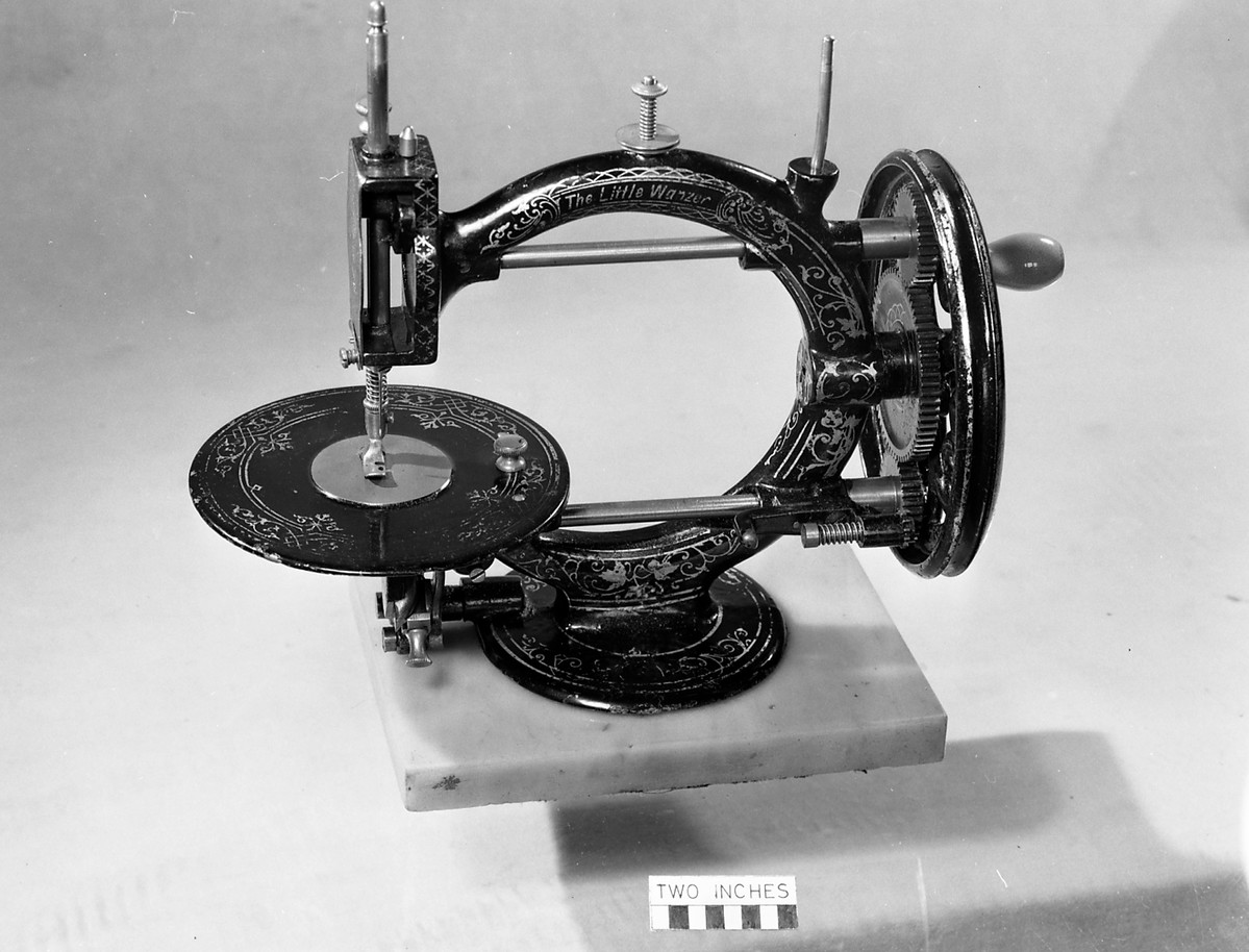 This is a ‘Little Wanzer’ lock knit sewing machine made by the Wanzer Sewing Machine Company of Great Portland Street London. It was patented on 16 May and 17 June 1867. The machine has a marble base and is stored in a wooden box along with several steel and brass attachments, including screws and a foot plate. The machine was in the donor’s husband’s family for many years and was in used until 1960. This isn't the same type that Lee invented, but his legacy lives on in every stitch. (MERL 60/133)