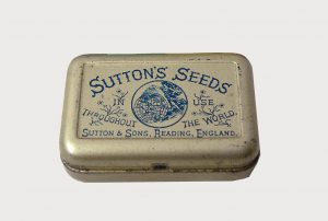 Small silvered tin with blue text and logo for Suttons Seeds on hinged lid