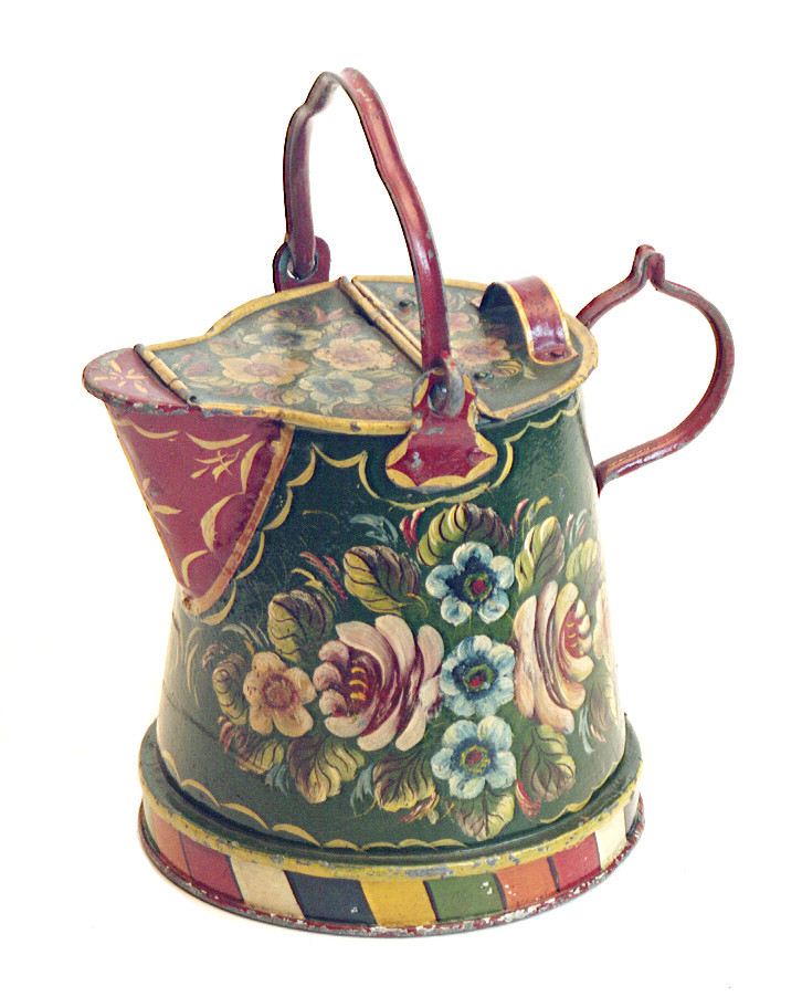 A water can for a canal boat. It is colourfully painted with a floral design in red, yellow, blue and white.