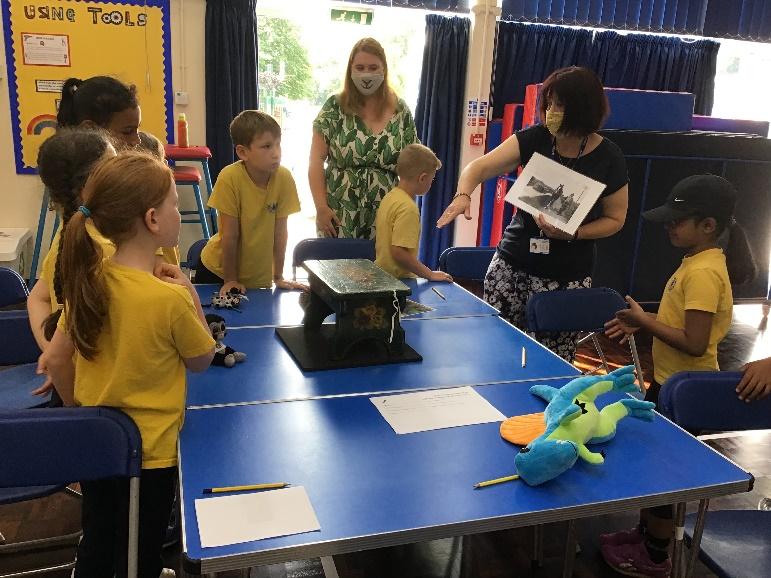 Children in a classroom looking at photographs.