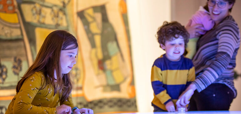 Family plays digital game in the MERL galleries at half term