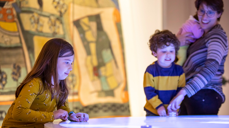 Family plays digital game in the MERL galleries at half term