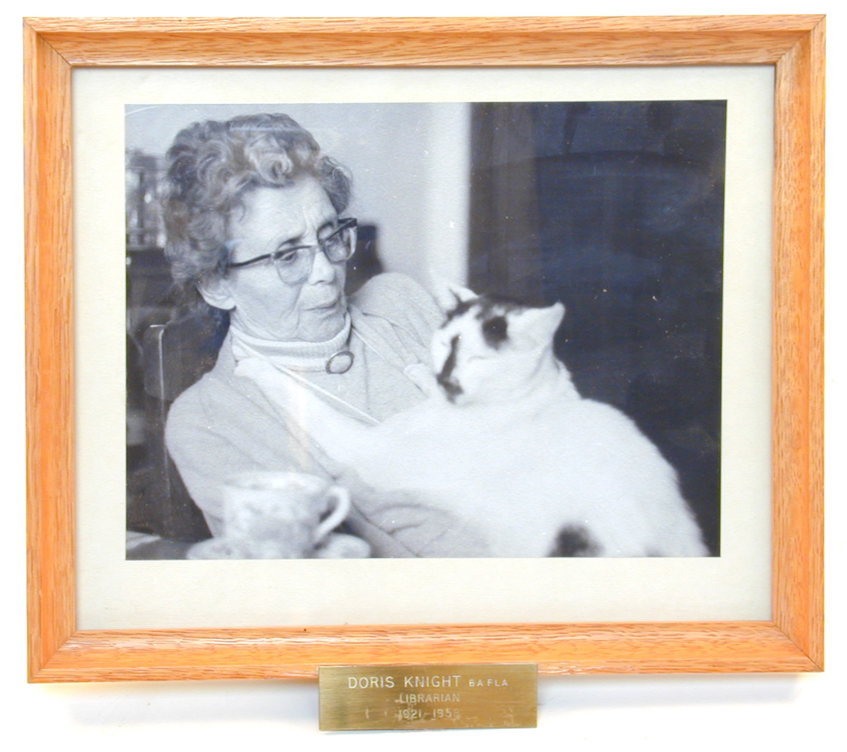 This is a framed photograph of Doris Knight who was a librarian at NIRD from 1921-1958. She is shown with her pet cat. The object is part of the NIRD Collection. (MERL 99/1)