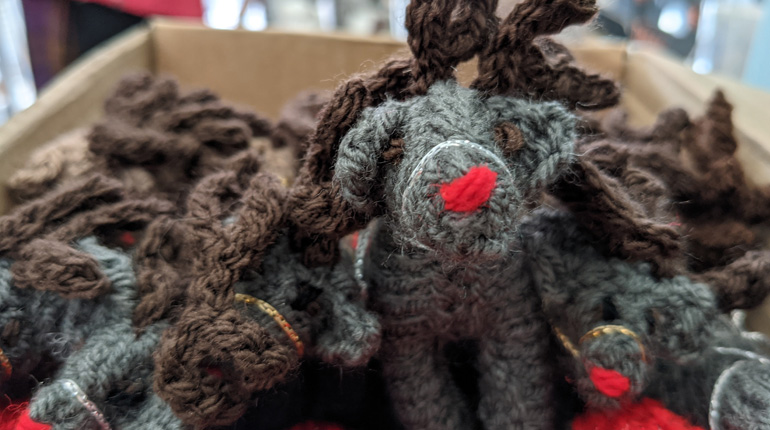 close up of a hand knitted reindeer Christmas decoration in the MERL gift shop