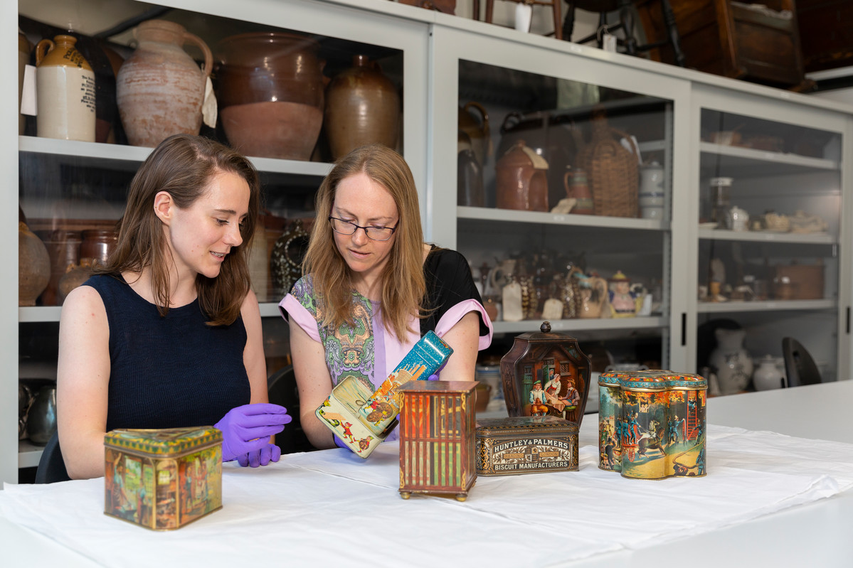 Two people look at objects from The MERL collection.