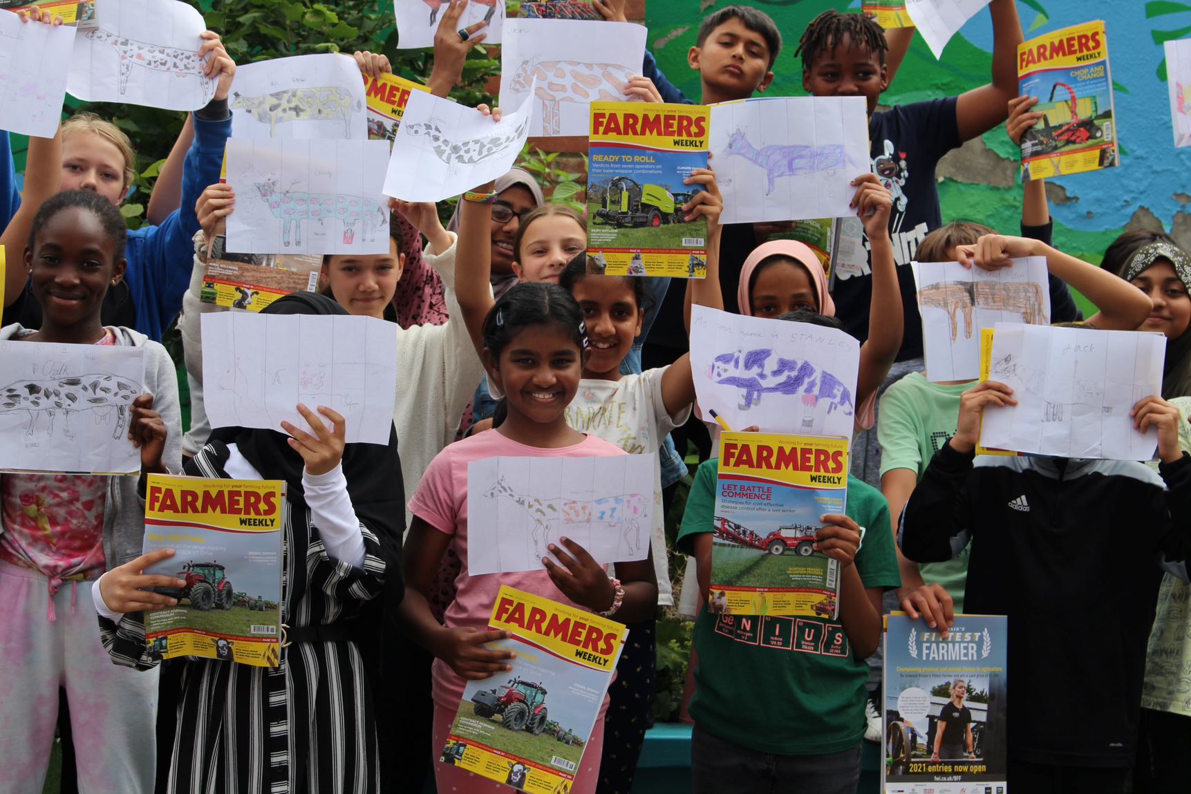 Children holding up pictures they made in the HaikuMoo workshop