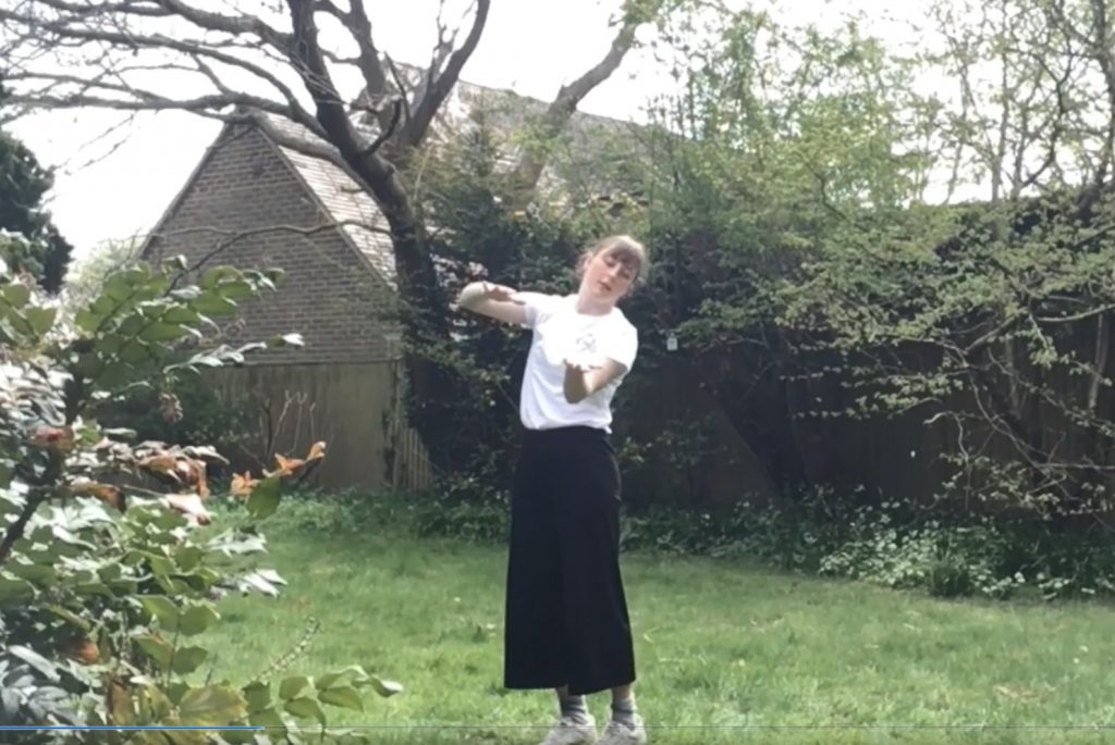 A woman in a dance pose in a garden