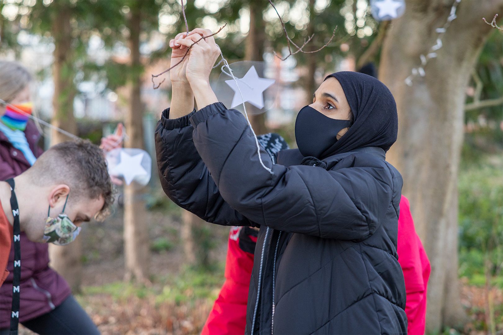 Volunteers putting up lights in The MERL garden.