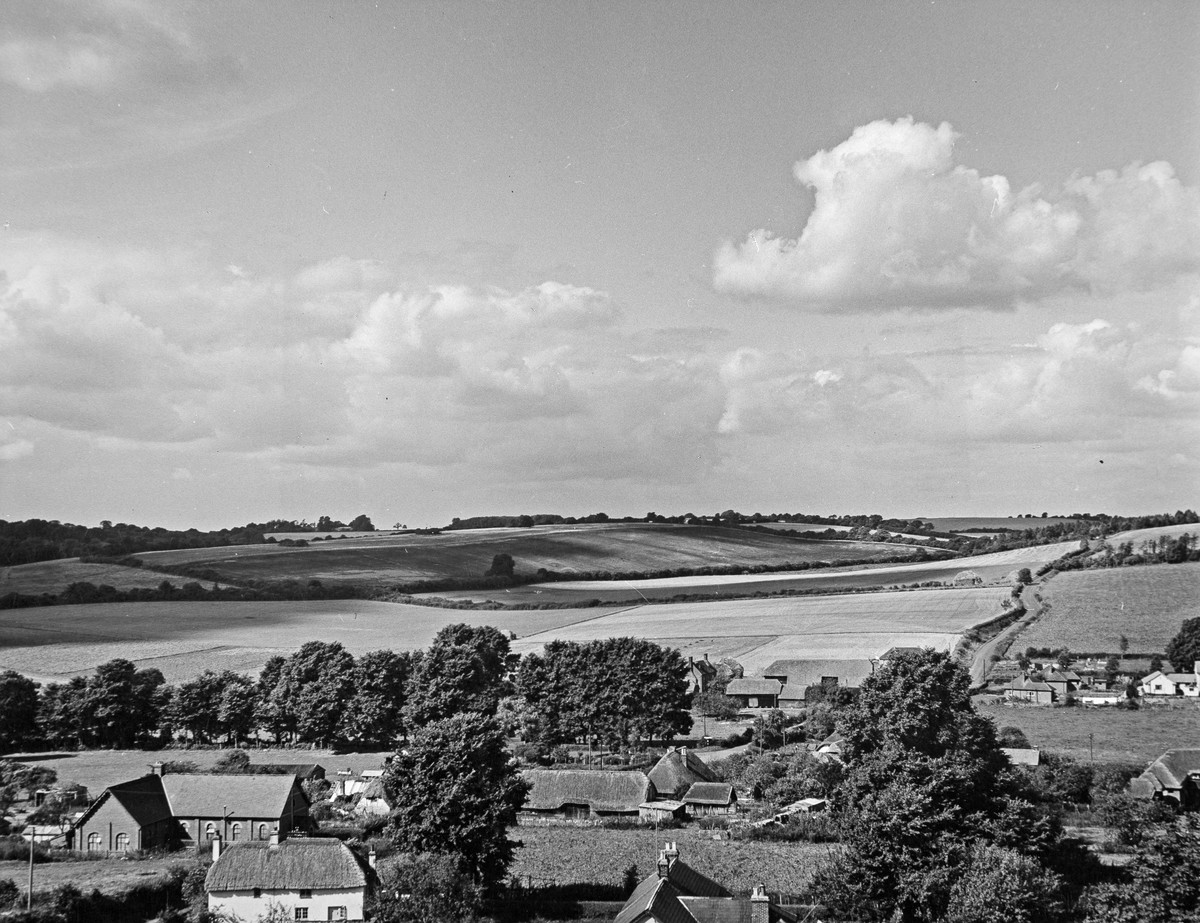 A black and white photograph of a countryside scene.