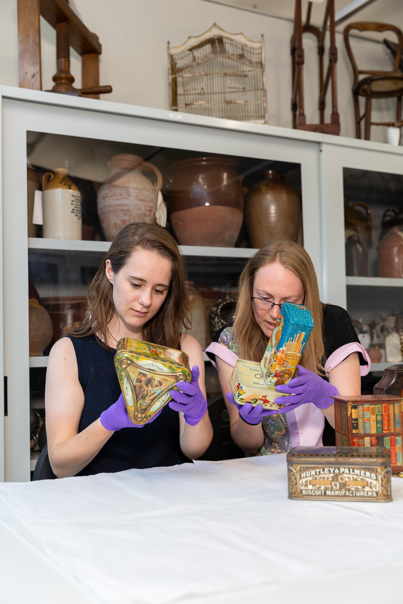 Two people handle objects from The MERL collection.