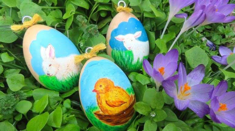 Painted Easter eggs sitting in grass and flowers
