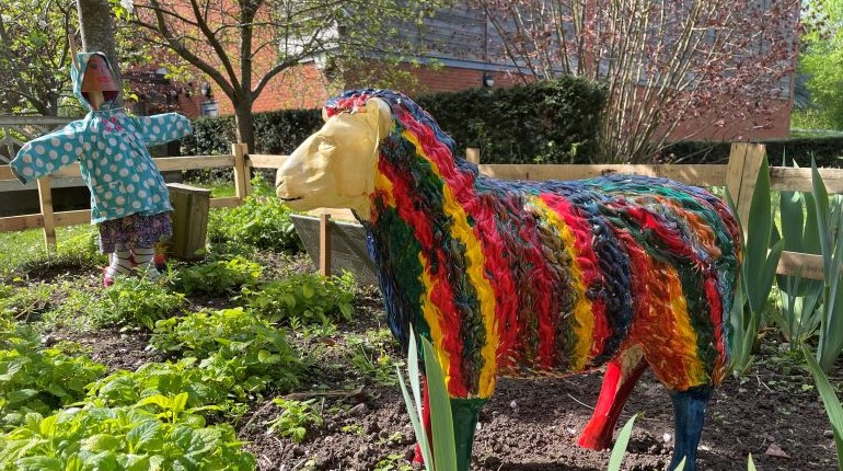 Sheep and scarecrow in the model farm in the herb garden