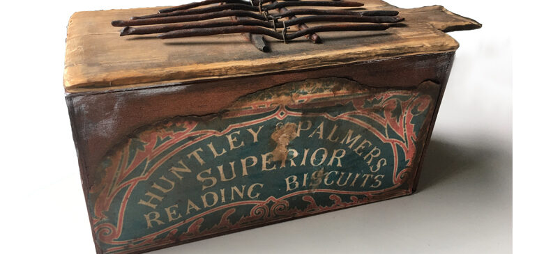 A Huntley & Palmers biscuit tin adapted into a musical instrument
