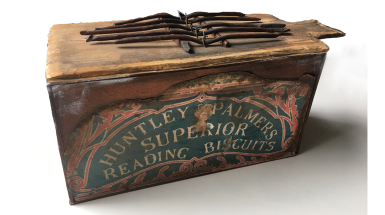A Huntley & Palmers biscuit tin adapted into a musical instrument