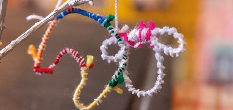 a colourful sheep decoration made from wool and pipecleaners
