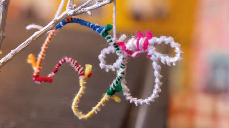 a colourful sheep decoration made from wool and pipecleaners