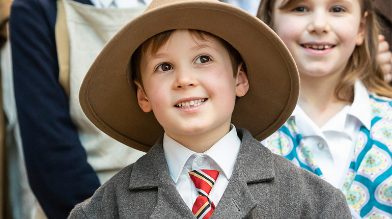 A boy dressed up in Victorian clothes.