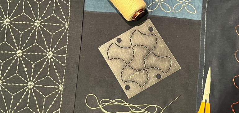 thread, fabric, scissors and a template laid out for japanese shashiko mending