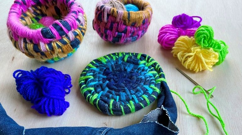 Fabric and wool laid out on a table next to fabric coil pots