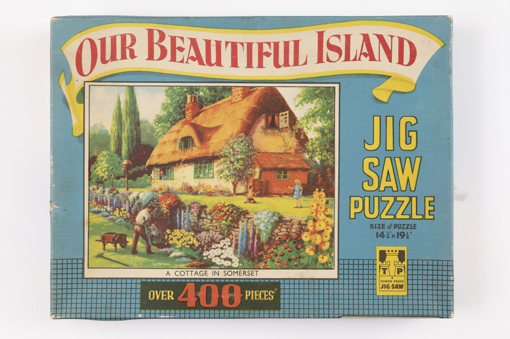 Jigsaw box entitled 'Our Beautiful Island' featuring a 'chocolate box' thatched cottage and garden