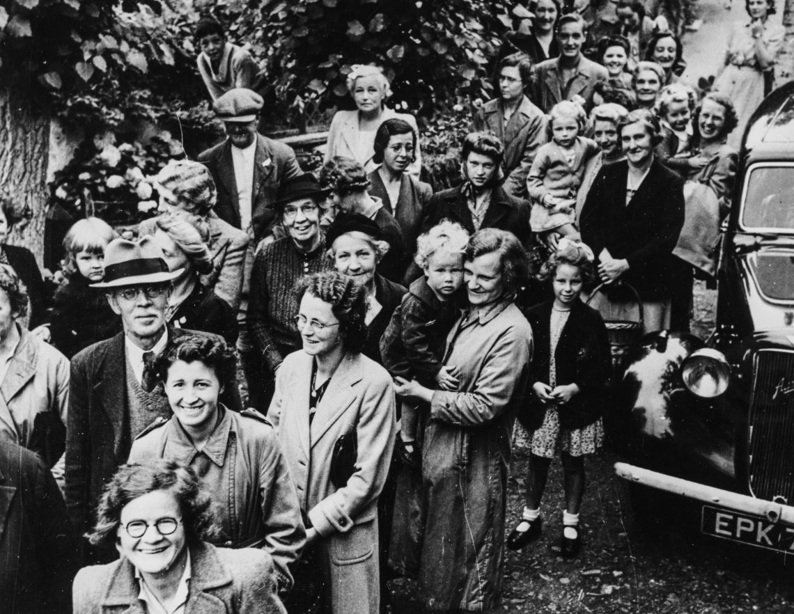 Black and white photograph of a crowd of smiling people