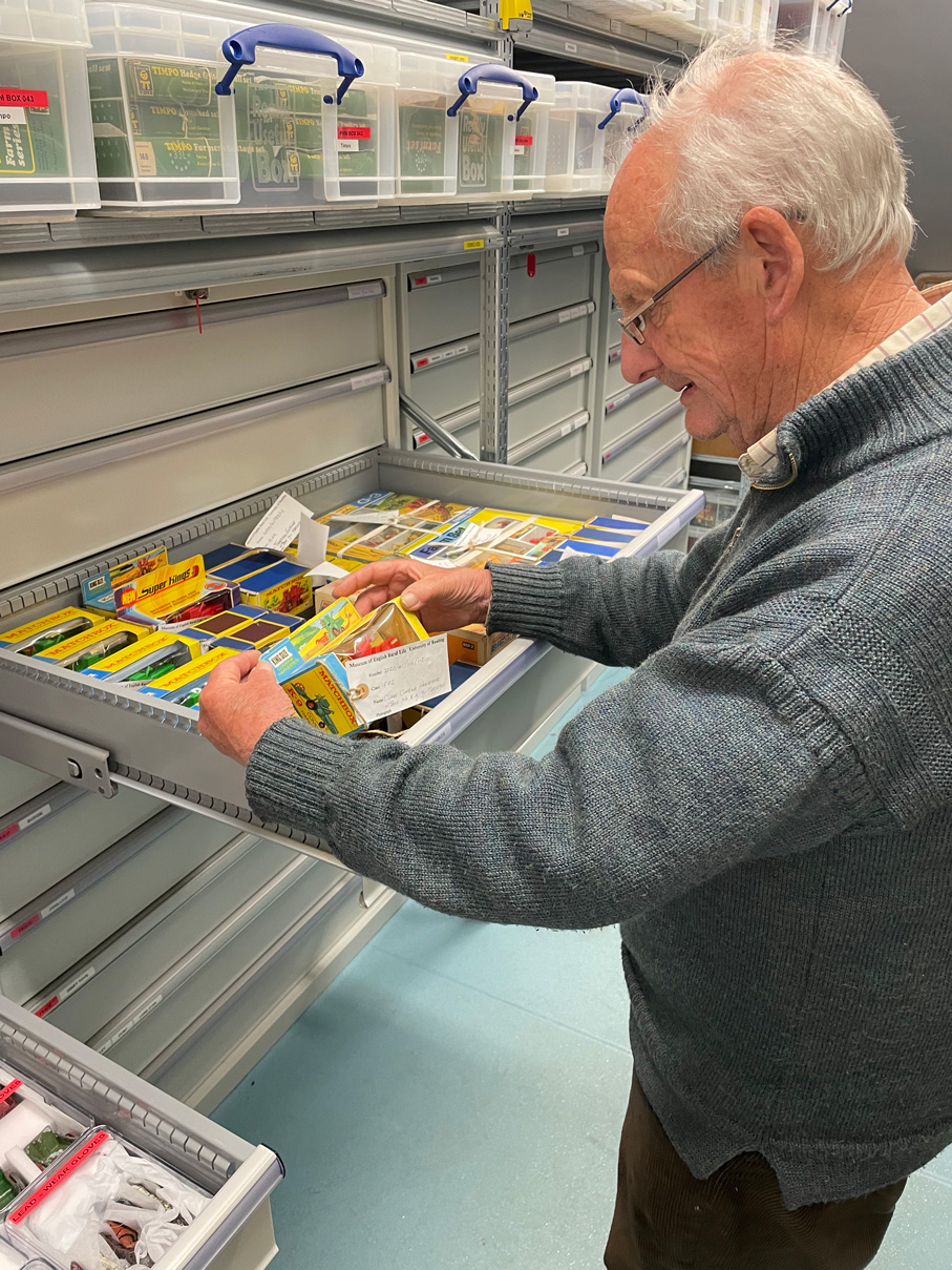 Farm toy collector Peter Wade-Martins looking at boxed toys in an open drawer