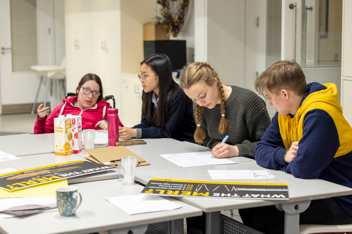 Young people looking at MERL publicity materials at a Youth Panel session