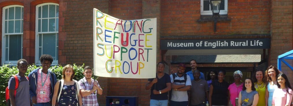 A group of people stand outside the Museum of English Rural Life holding a banner that reads 