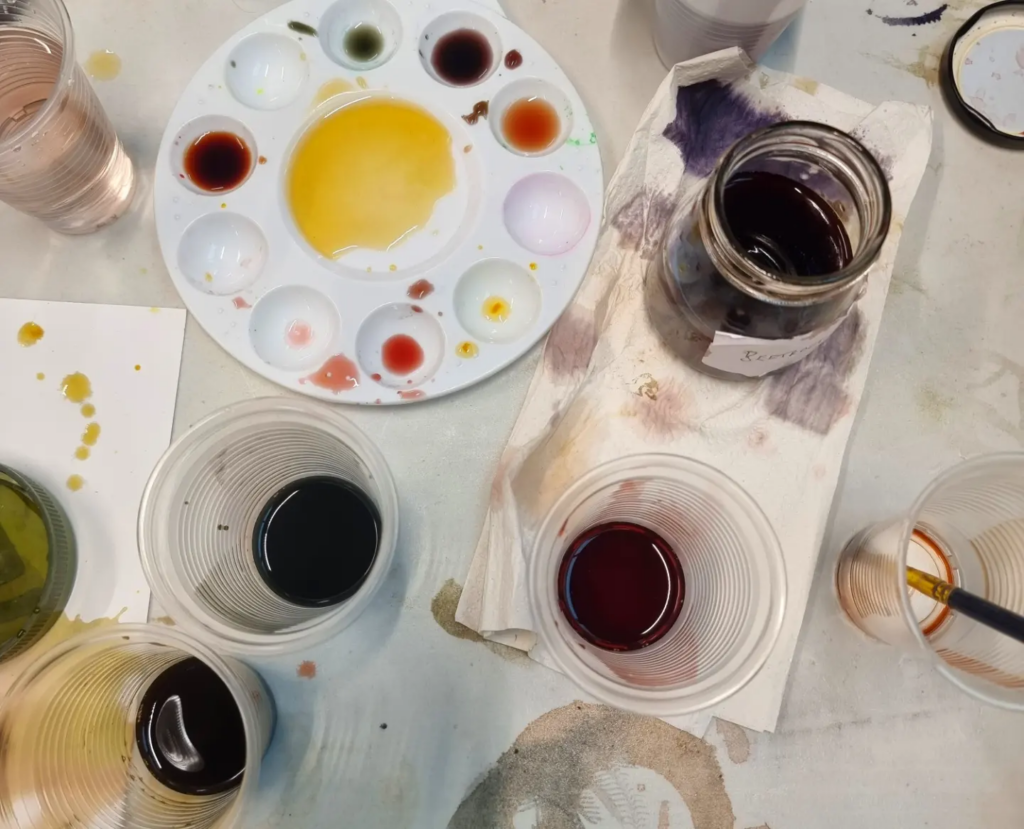 jars, paint palettes and plastic cups holding vegetable-based dyes from the MERL garden