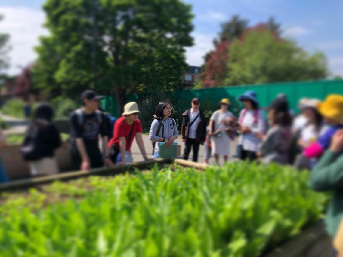 Perle in an allotment, giving a talk to other food growers