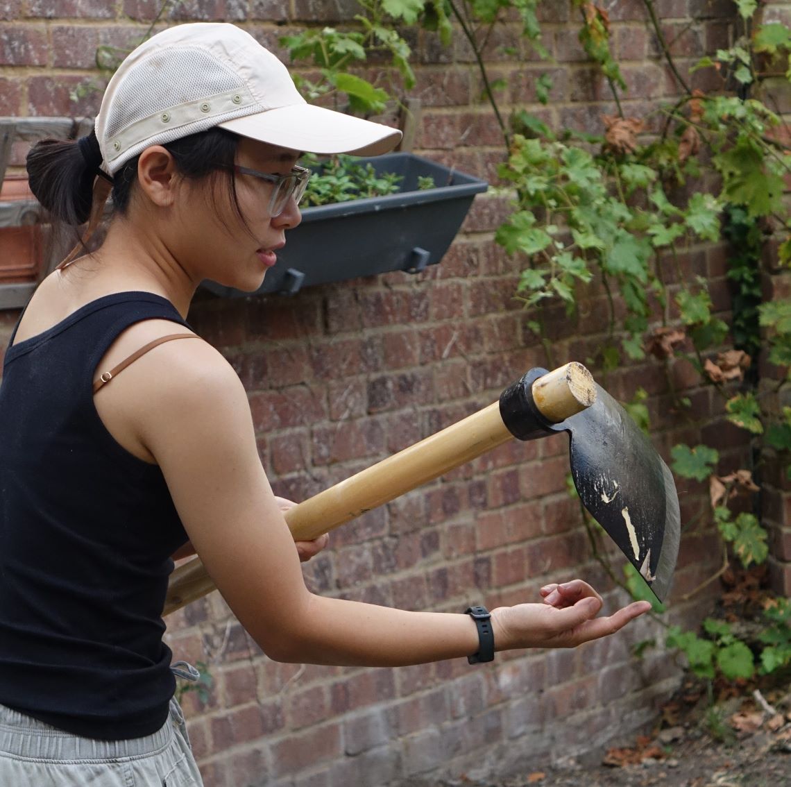 Perle Wong holding her cultivating tool