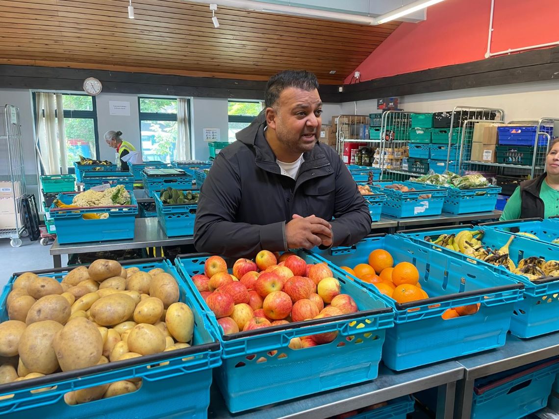 Taz Khan surrounded by crates of fruit and veg