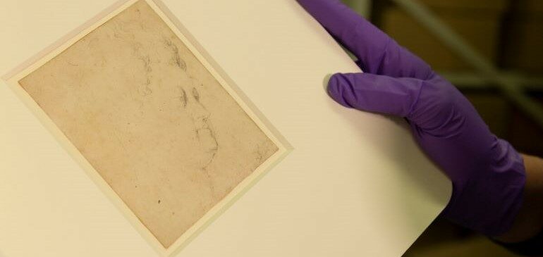 A person with purple gloves holding a Study for the head of Marie de'Medici