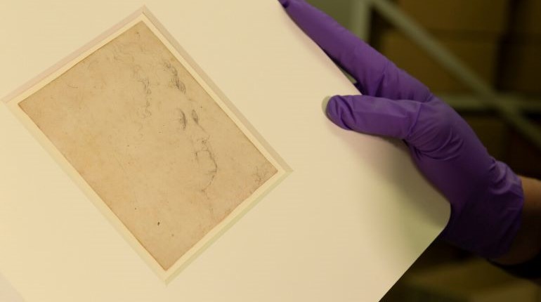 A person with purple gloves holding a Study for the head of Marie de'Medici