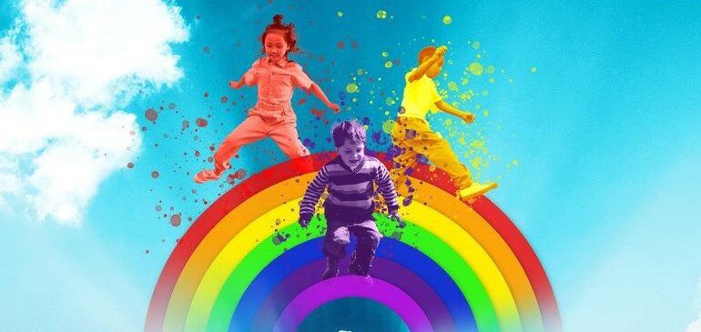 Children happily jumping over a rainbow with a blue sky and stars in the background