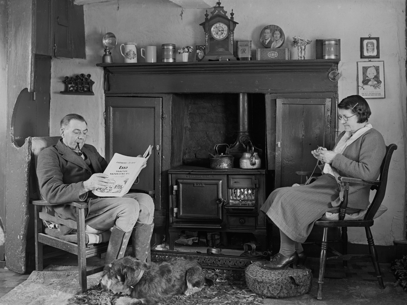 A couple sit by a fireplace