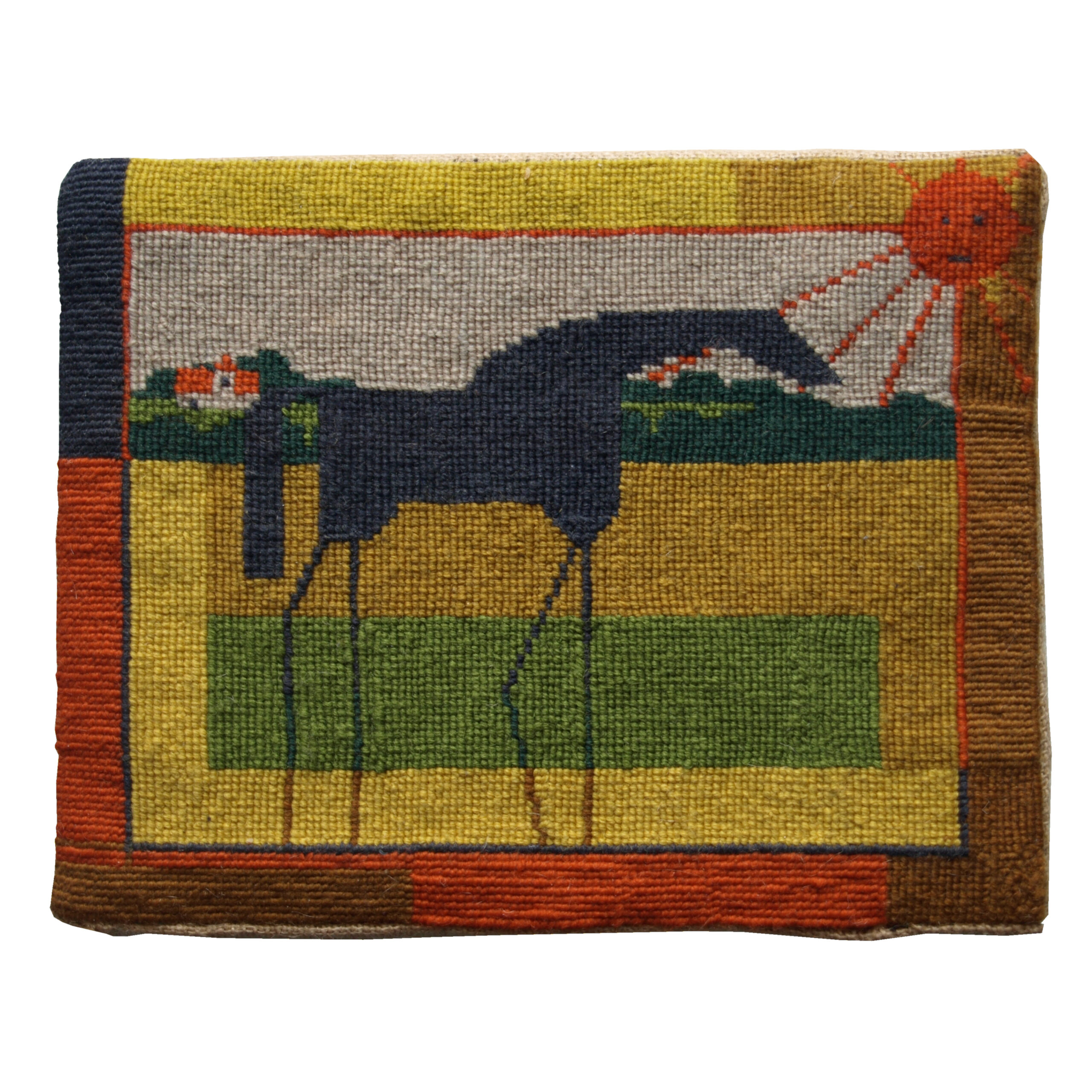 A hassock of a black horse, stood in a field with a rural backdrop.